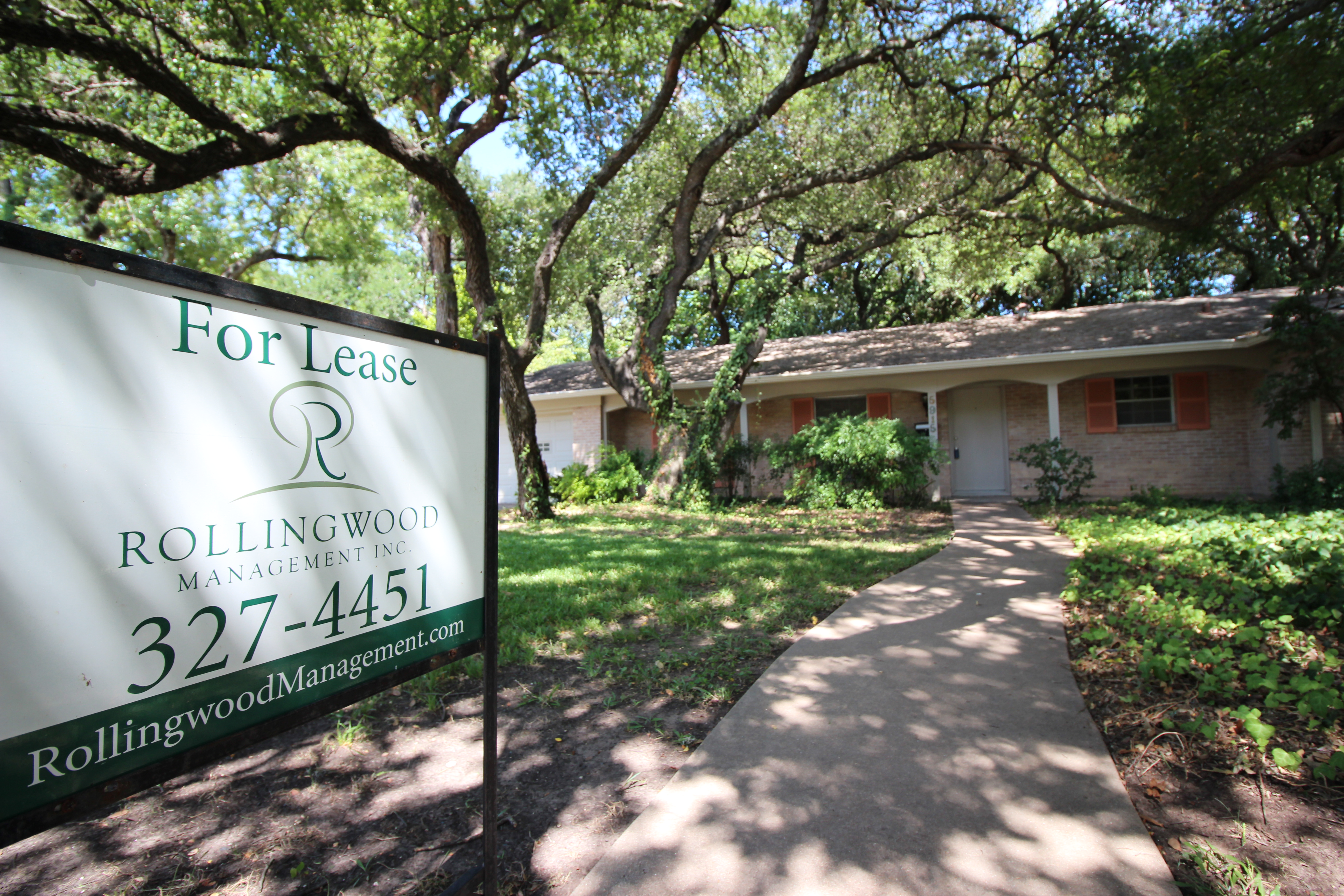 a Rollingwood Management Inc. sign in front of a house